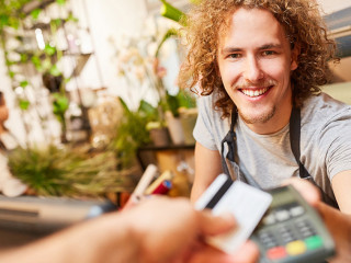 Kartenzahlung im Einzelhandel: Kunde bezahlt an der Kasse mit Debit- oder Kreditkarte