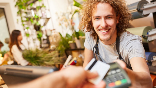 Kartenzahlung im Einzelhandel: Kunde bezahlt an der Kasse mit Debit- oder Kreditkarte