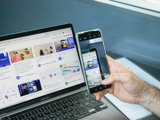 Close-up of a smartphone capturing a laptop screen, representing technology integration.