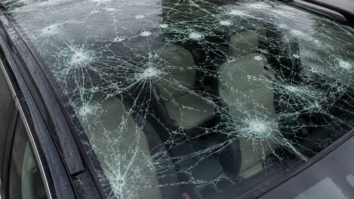 Schon kleine Hagelkörner können eine Autoscheibe beschädigen. Welche Rolle Hitze spielt, wie sich Schäden vermeiden lassen und wann die Teilkasko die Kosten übernimmt.